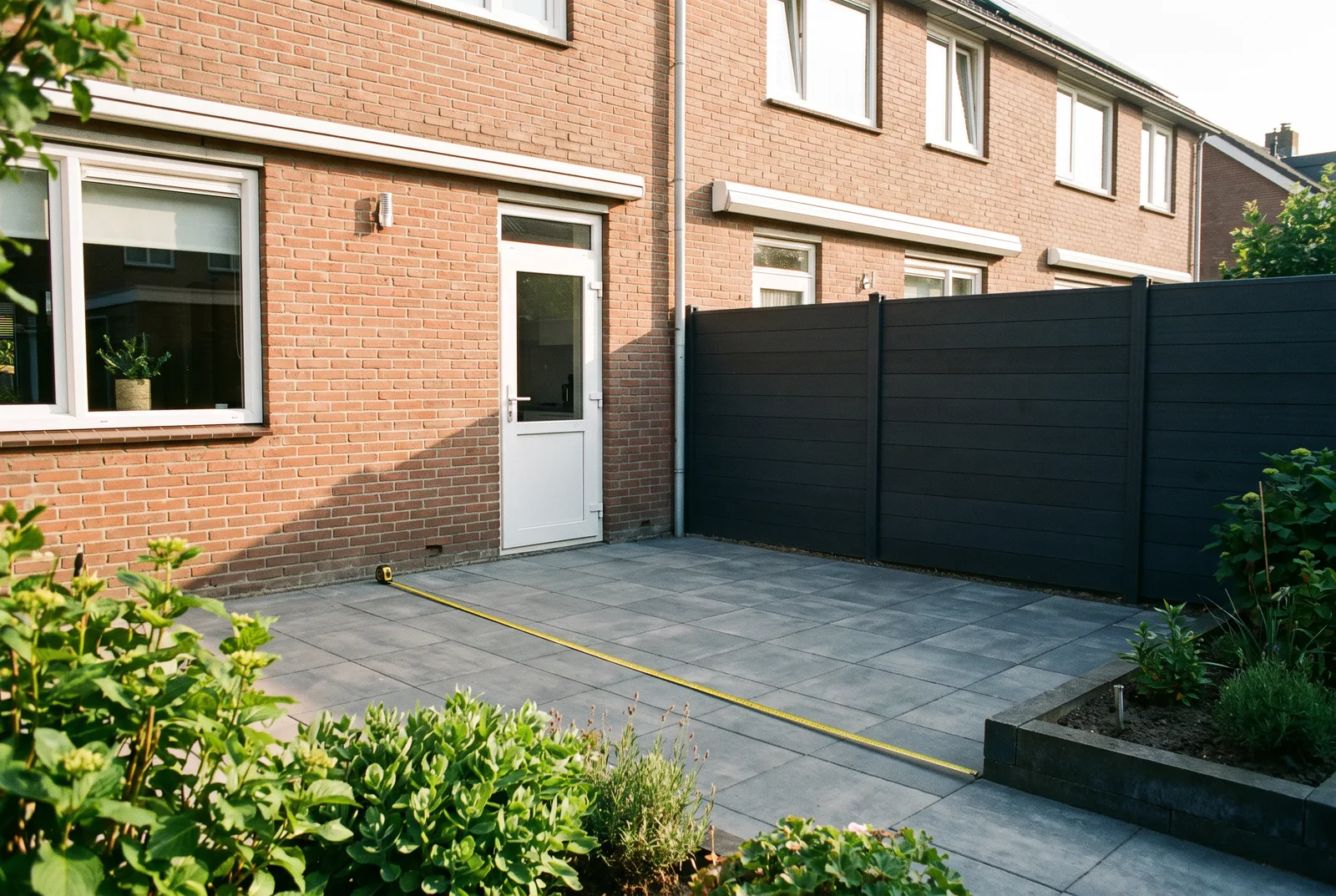 De achtergevel en de tuin van een rijwoning, op de plek waar een uitbouw zou komen