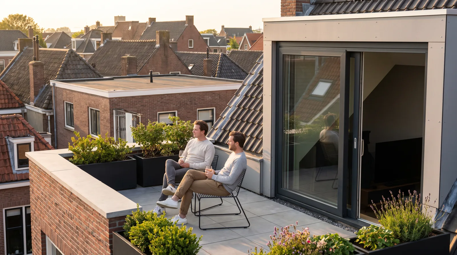 Bewoners zitten 's avonds op het nieuwe dakterras op de opbouw van hun huis