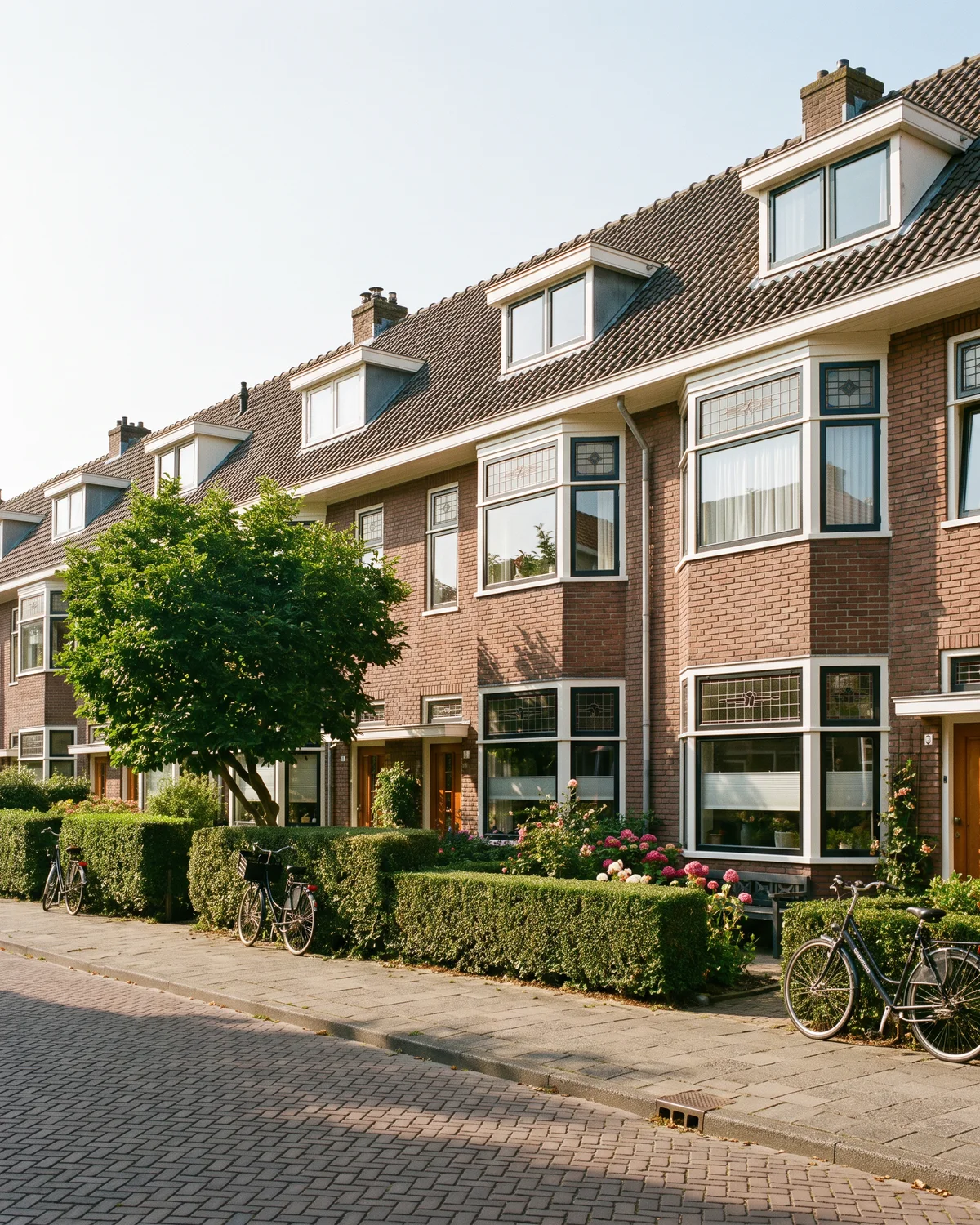 De voorkant van een rij jaren-dertigwoningen op een zonnige dag